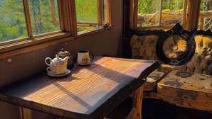 A wooden table with a checkered tablecloth, a teapot, and a cup on it. - Charming TREEHOUSE in remote location (Braintree)