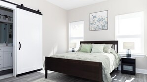 Une chambre à coucher comprenant un lit, des tables de chevet, une armoire et une fenêtre avec des stores.