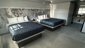 A modern hotel room with two beds, marble headboard, and a large window. - Hometown Inn (Los Banos)