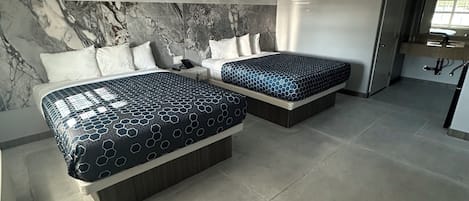 A modern hotel room with two beds, marble headboard, and a large window.