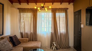 Una sala de estar acogedora con un sofá, una mesa de centro de vidrio y una escultura decorativa.