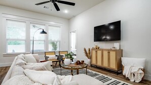 En moderne stue med sofa, sofabord og fjernsyn.