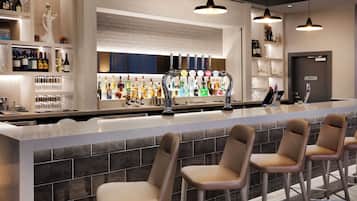 A bar area with a counter, multiple taps, and bar stools.