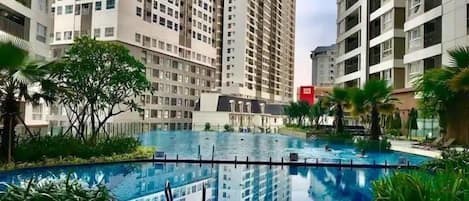 Alberca al aire libre, sombrillas en la alberca y camastros