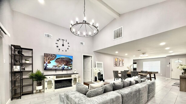 A spacious living room with a large sectional sofa, a flat-screen TV, a fireplace, and a dining area with a table and chairs. - NRG Stadium - Pool table, Patio, & Grill (Houston)