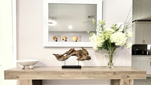 A wooden console table with a decorative piece and a vase of flowers. - NRG Stadium - Pool table, Patio, & Grill (Houston)