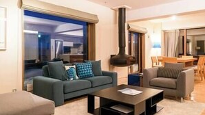 Una sala de estar moderna con un sofá, sillones, una mesita de centro y una chimenea.