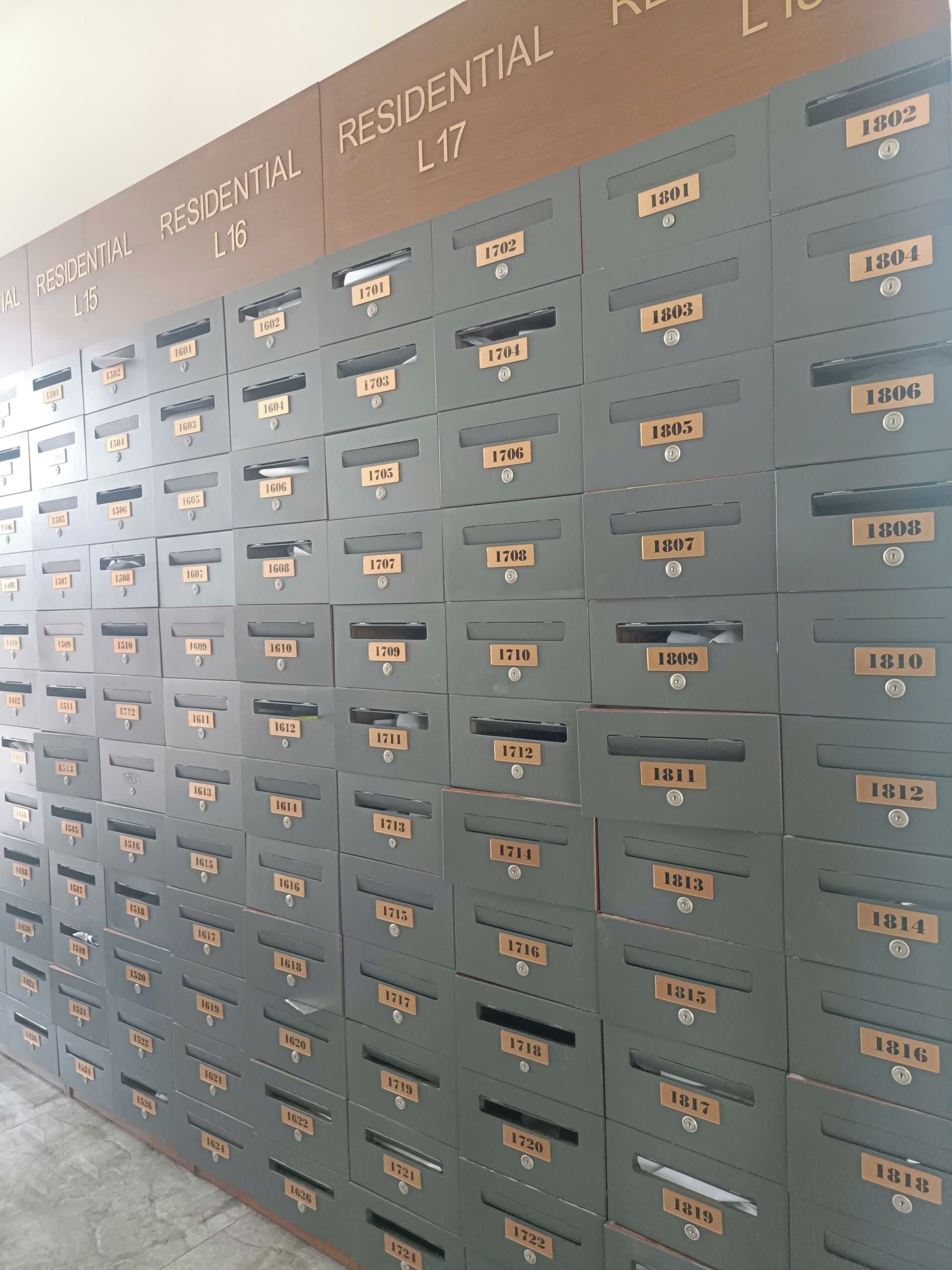 A row of grey metal mailboxes with labels ranging from L15 to L17, each with a unique number.