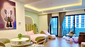 A modern hotel room with a large window, a round dining table, and comfortable seating. - FLC Sea Tower Quy Nhon Apartment (Quy Nhon Nam)