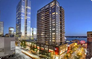 A modern high-rise building with multiple floors, large windows, and a well-lit facade.