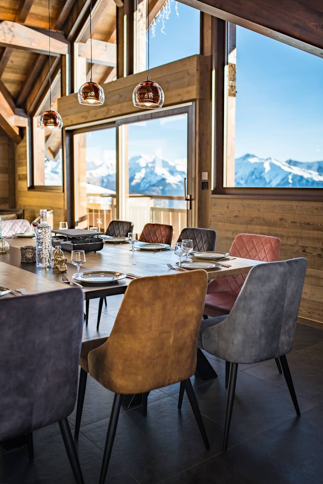 Un comedor con interior de madera, ventanas amplias y vistas a la montaña.