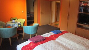 A hotel room with a bed, a desk with a chair, a television, and a wardrobe. - Vacation apartment near the old town and lake (Neubrandenburg)