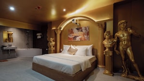 A modern bedroom with a large bed, a bathtub, and a golden statue. - Love in the Atlantis Hotel (Hanoi)