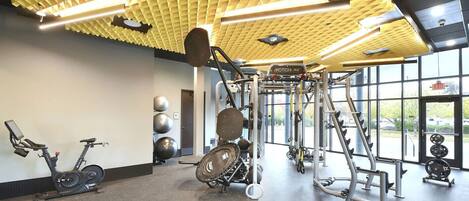 A gym with exercise equipment, a stationary bike, and large windows.