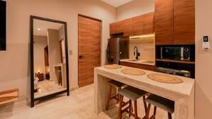 Una cocina moderna con armarios de madera, un microondas empotrado y un espejo grande.