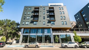 Un edificio de varias plantas con un diseño moderno, que cuenta con balcones y grandes ventanales.
