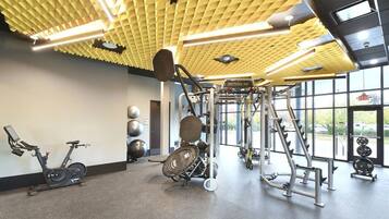 A gym with exercise equipment, a stationary bike, and large windows.