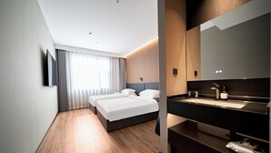 A modern hotel room with a large bed, a built-in desk, a vanity with a mirror, and a large window with curtains. - xihe Langyue Hotel  (Beijing)