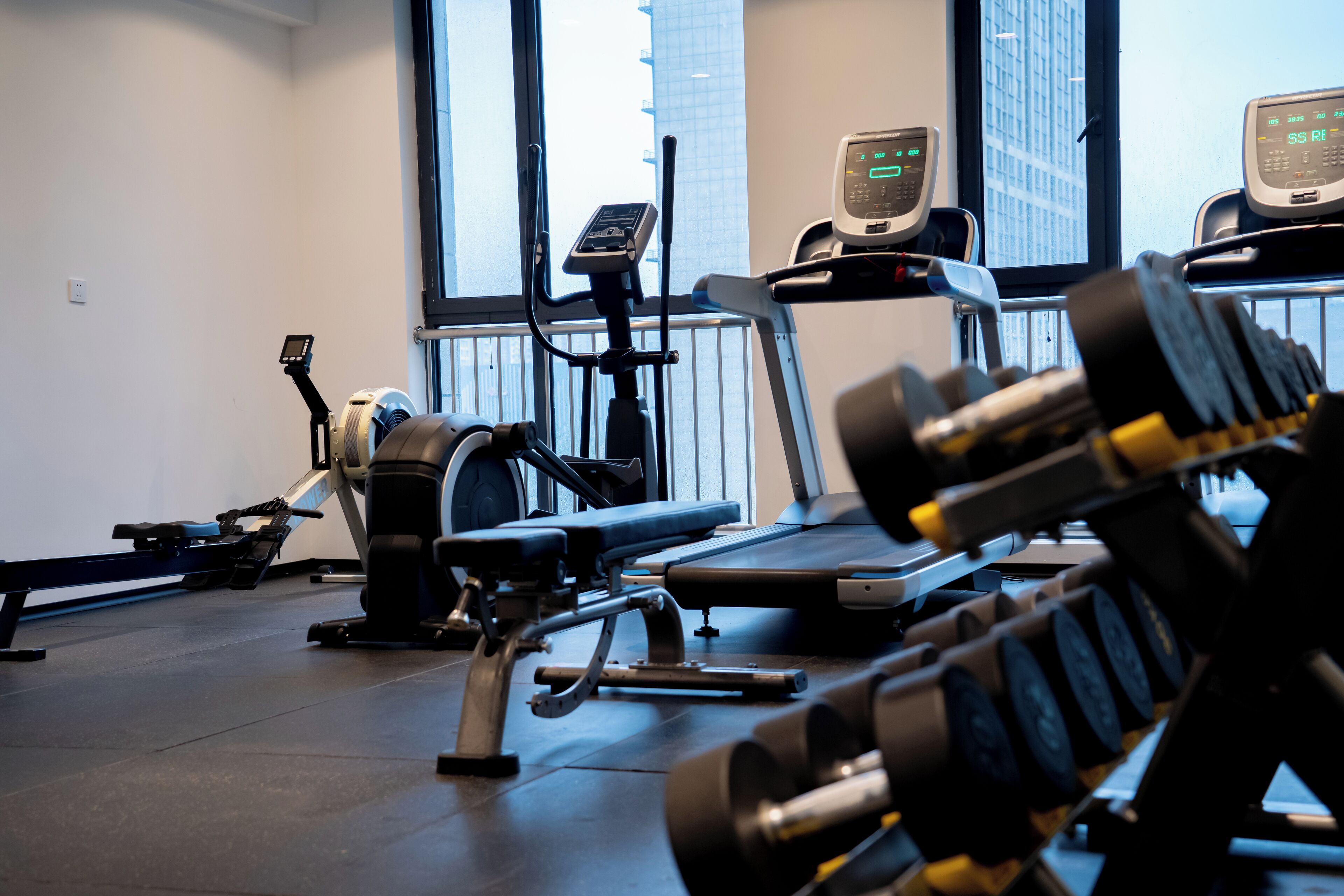 A gym with exercise equipment including a treadmill, stationary bike, and weight machines.