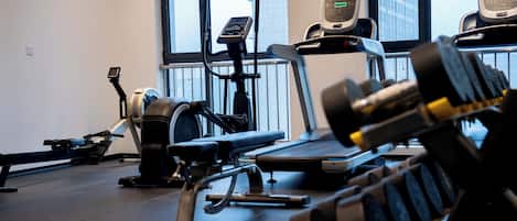 A gym with exercise equipment including a treadmill, stationary bike, and weight machines.