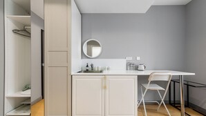 A compact kitchen with a white countertop, a sink, and a round mirror above it. - xihe Langyue Hotel  (Beijing)