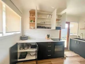 A modern kitchen with built-in cabinets, a countertop, and a window.
