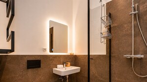Un bagno moderno con lavandino bianco, un water e uno spazio doccia.