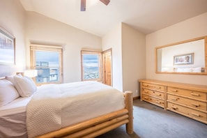 Un dormitorio con una cama grande, un aparador de madera y vistas por la ventana.