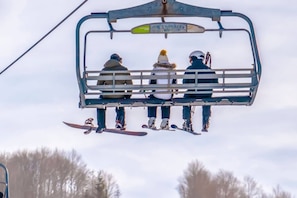 A ski lift with three skiers seated.