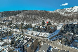 A residential area with modern houses, a ski lift, and a mountain backdrop.