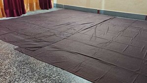 A room with a large, dark-colored mat covering the floor.