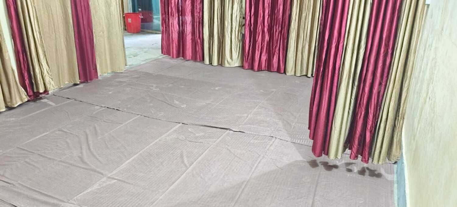 A room with a tiled floor and red and beige curtains.