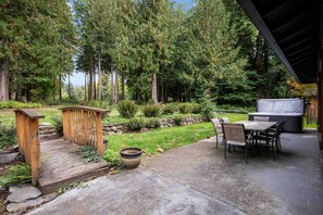 A patio area with a wooden deck, a barbecue grill, and a seating arrangement. - Alpine Getaway w/ Hot Tub, Firepit & Stunning Views, Pet Friendly, Near Mt. Hood Slopes (Welches)