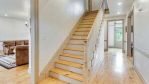 Una escalera de madera con barandilla que conduce a un piso superior.