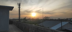 A sunset over a bridge with buildings and a communication tower in the background. - Pradnya Homestay - 1Bedroom Near Uluwatu (Ungasan)