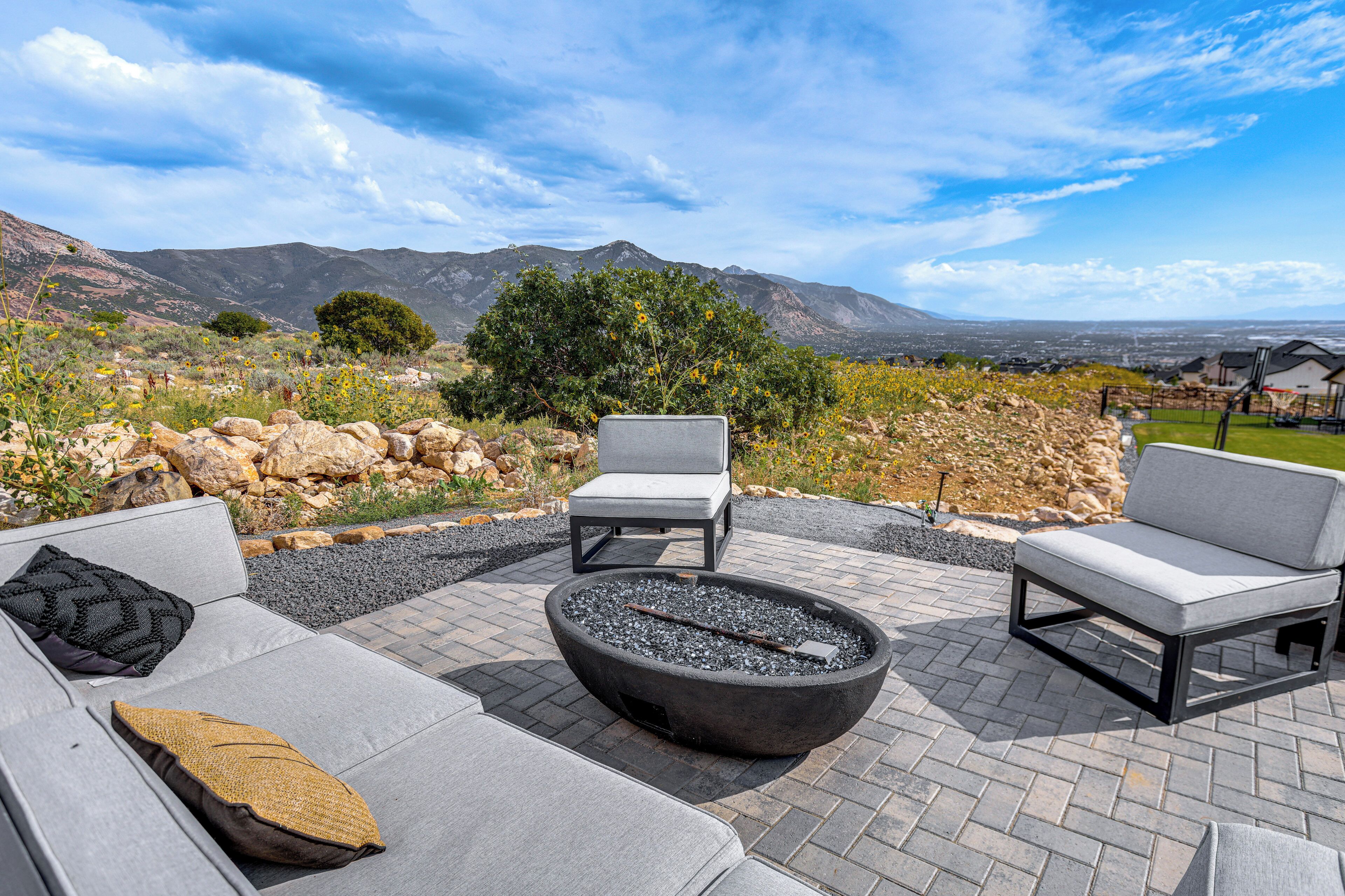 A patio with outdoor furniture, a fire pit, and a scenic mountain view.