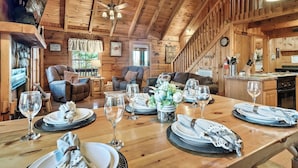 Un intérieur en bois comprenant une table à manger pour six personnes, un canapé et un coin cuisine.