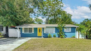 A single-story house with a front yard, a white picket fence, and a small tree. - Home w/ Expansive Patio, 3 Mi to Busch Gardens! (Tampa)