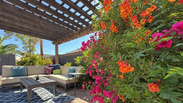 An outdoor patio with a wooden pergola, a sofa set, and a table. - Old Town Scottsdale / 4 Bedroom House (Scottsdale)