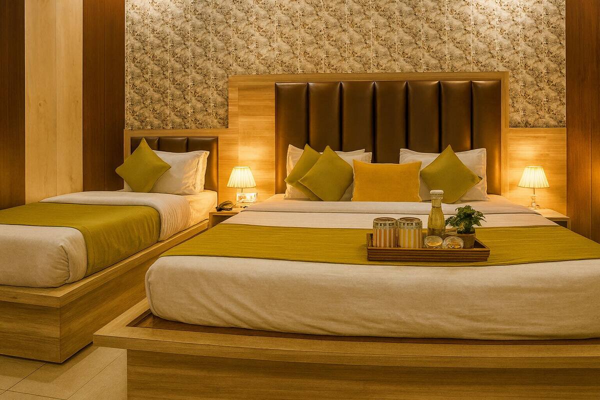 A hotel room with two beds, a wooden headboard, and a floral wallpaper.