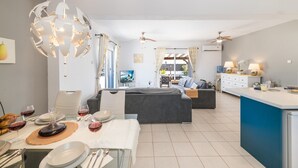 Una cocina moderna con comedor, que incluye una isla central, iluminación colgante y un ventilador de techo.