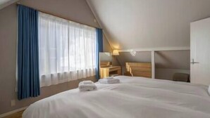 Un dormitorio con una cama grande, un escritorio y una silla.