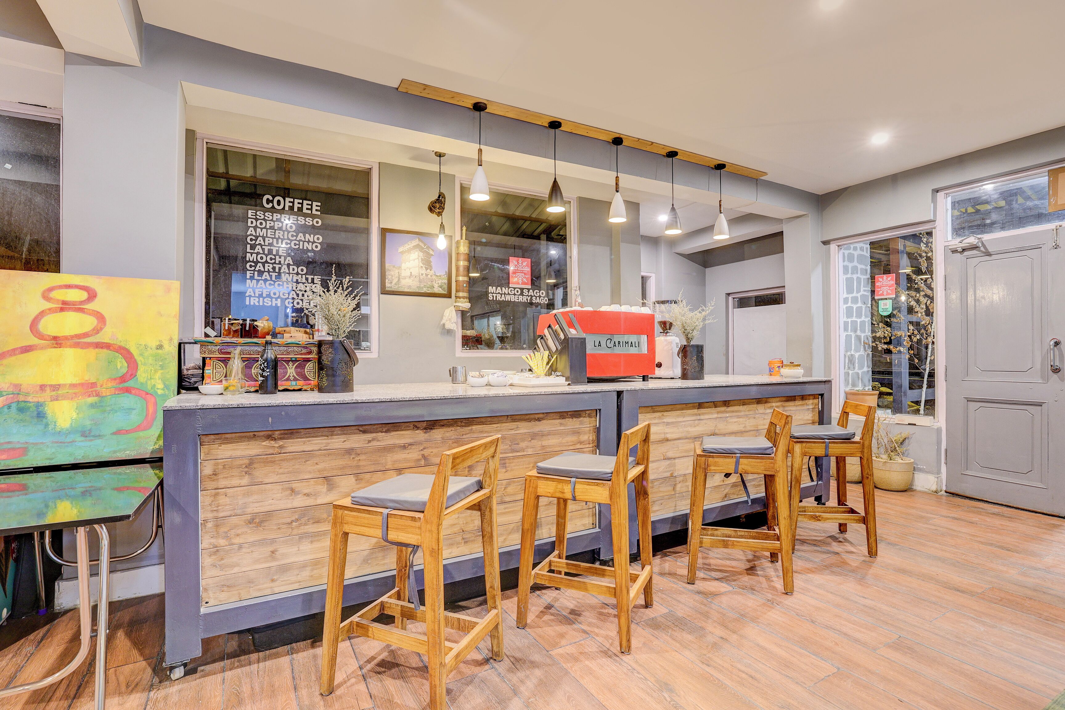 A coffee shop with a bar area, wooden chairs, and a coffee machine.
