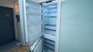 Et moderne køkken med indbygget køleskab, mikroovn og vask.