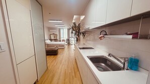 Et moderne hotelværelse med tekøkken, seng og badeværelse.