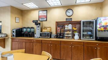 A breakfast bar with coffee machines, a microwave, and a juice dispenser.