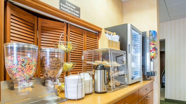 Balcão de café da manhã com cereais, doces e máquina de café.