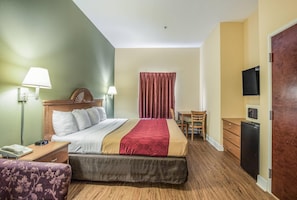 Een hotelkamer met een bed, nachtkastjes, een bureau, een stoel, een televisie en een kledingkast.
