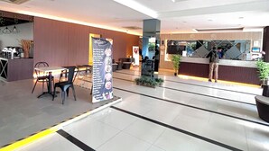 A spacious lobby with a reception desk, seating area, and a bulletin board. - SERRA HOTEL BATAM (Batam)