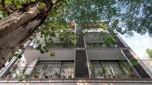 Un edificio de varios pisos con balcones, cada uno decorado con macetas de plantas.